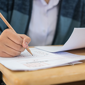 Student taking completing an exam paper